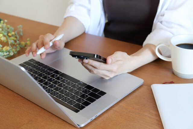 PCとスマホで仕事をする女性