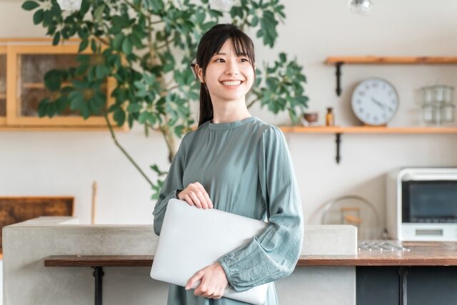 PCを抱えて笑顔の女性