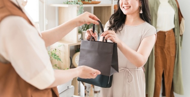 店員から購入商品を受け取る顧客