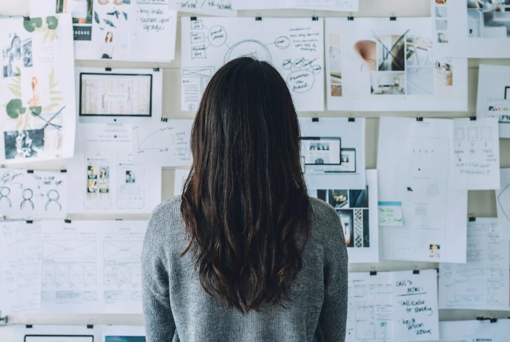 工務店のマーケティング重点施策を壁一面の資料を見ながら戦略的に考える担当者