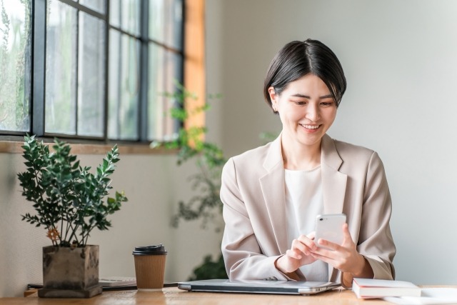 PCとスマホで作業する女性
